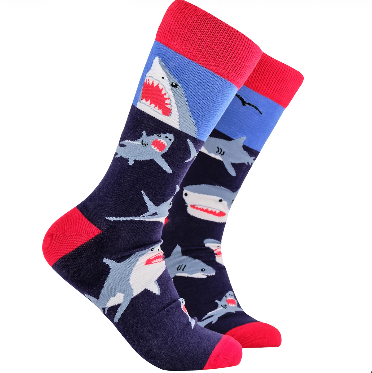 A pair of crew socks with a shark pattern, featuring a navy blue body, red heels and toes, and a light blue section near the top with gray and white sharks.