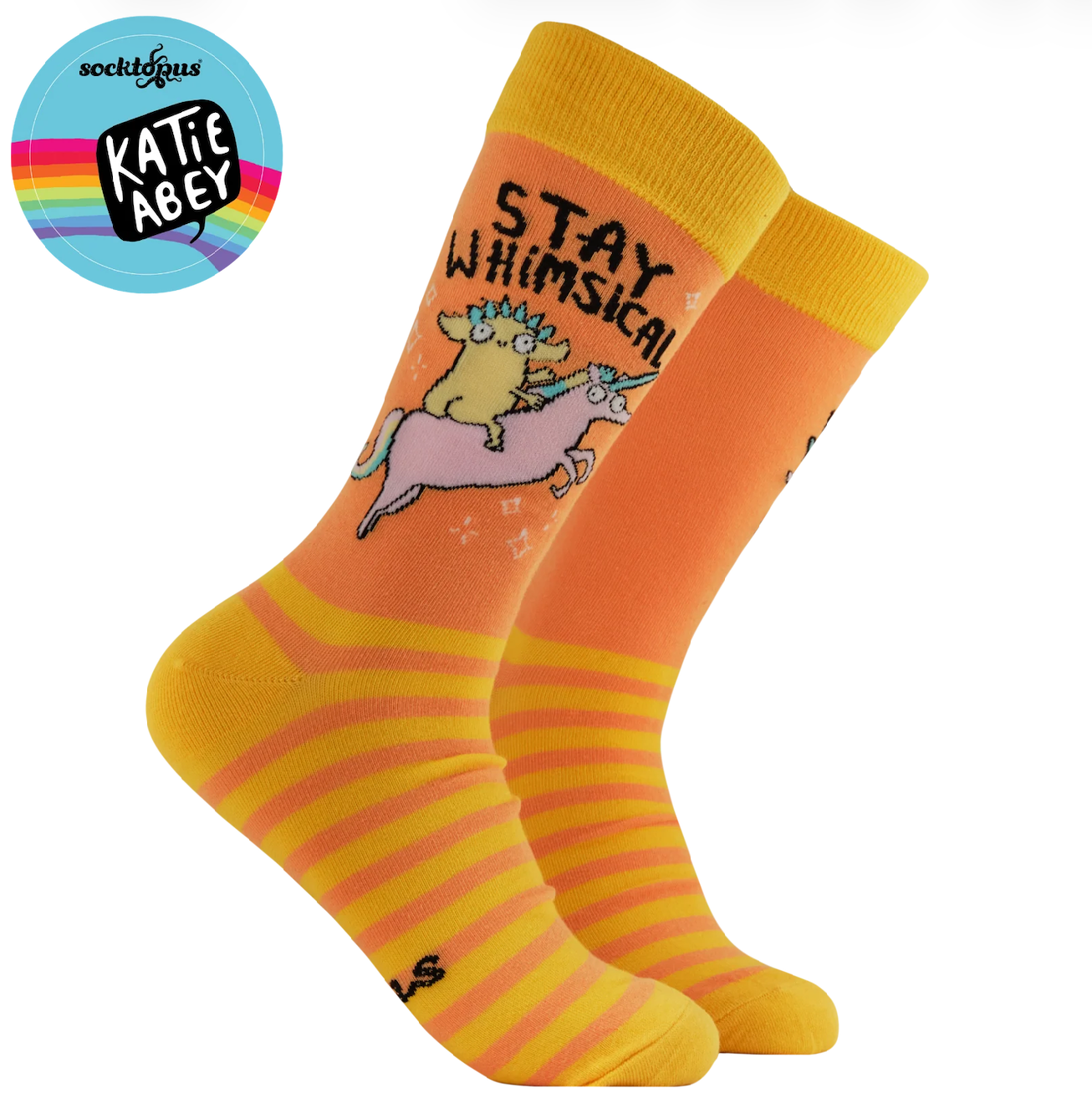 A pair of bright orange and yellow crew socks with a whimsical cartoon design. The design features a yellow creature riding a pink unicorn with the text 'STAY WHIMSICAL' printed on the side.