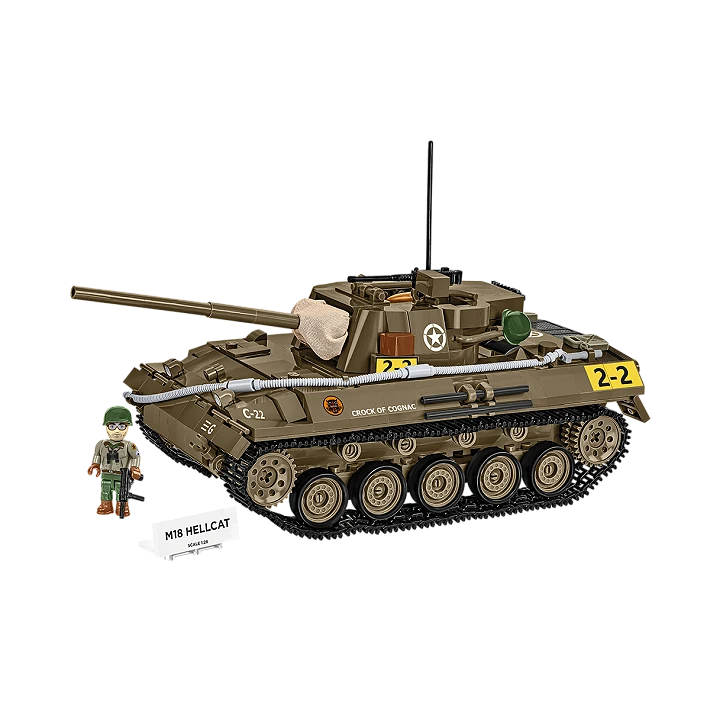 A photo of the model tank. It is made of various brown, grey and yellow pieces. It has its gun raised, and has functional tracks over its wheels. A model soldier stands next to it, behind a small plaque displaying the name of the tank.