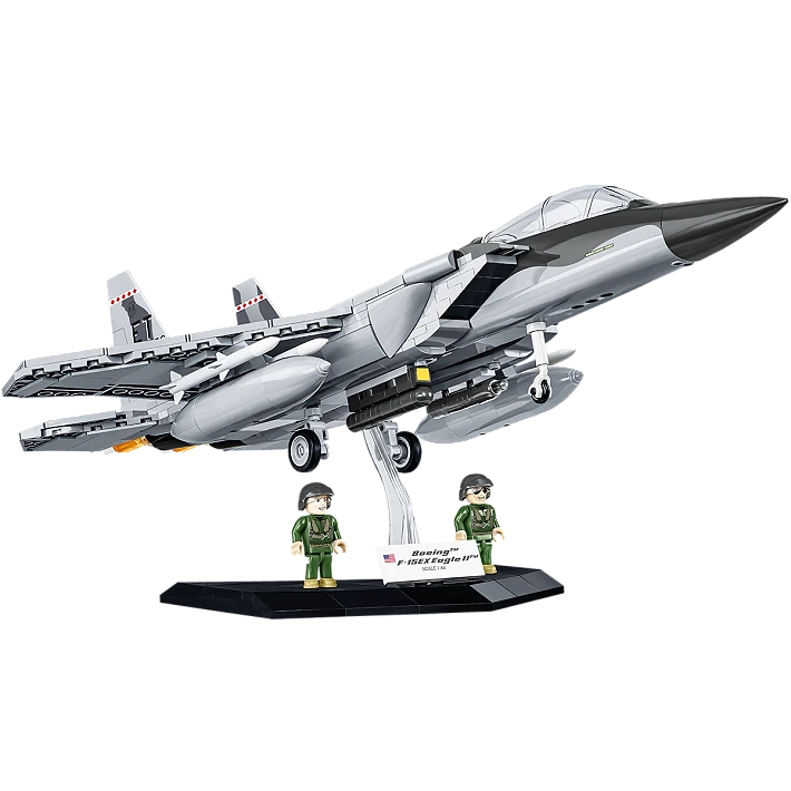 A photograph of the assembled model displayed on its stand. Two model people in green flight suits are stood on the stand, next to a white plaque bearing the aircraft's name and country of origin. The plane is constructed of numerous light and dark gray pieces, and has multiple bombs and missiles mounted beneath its wings.