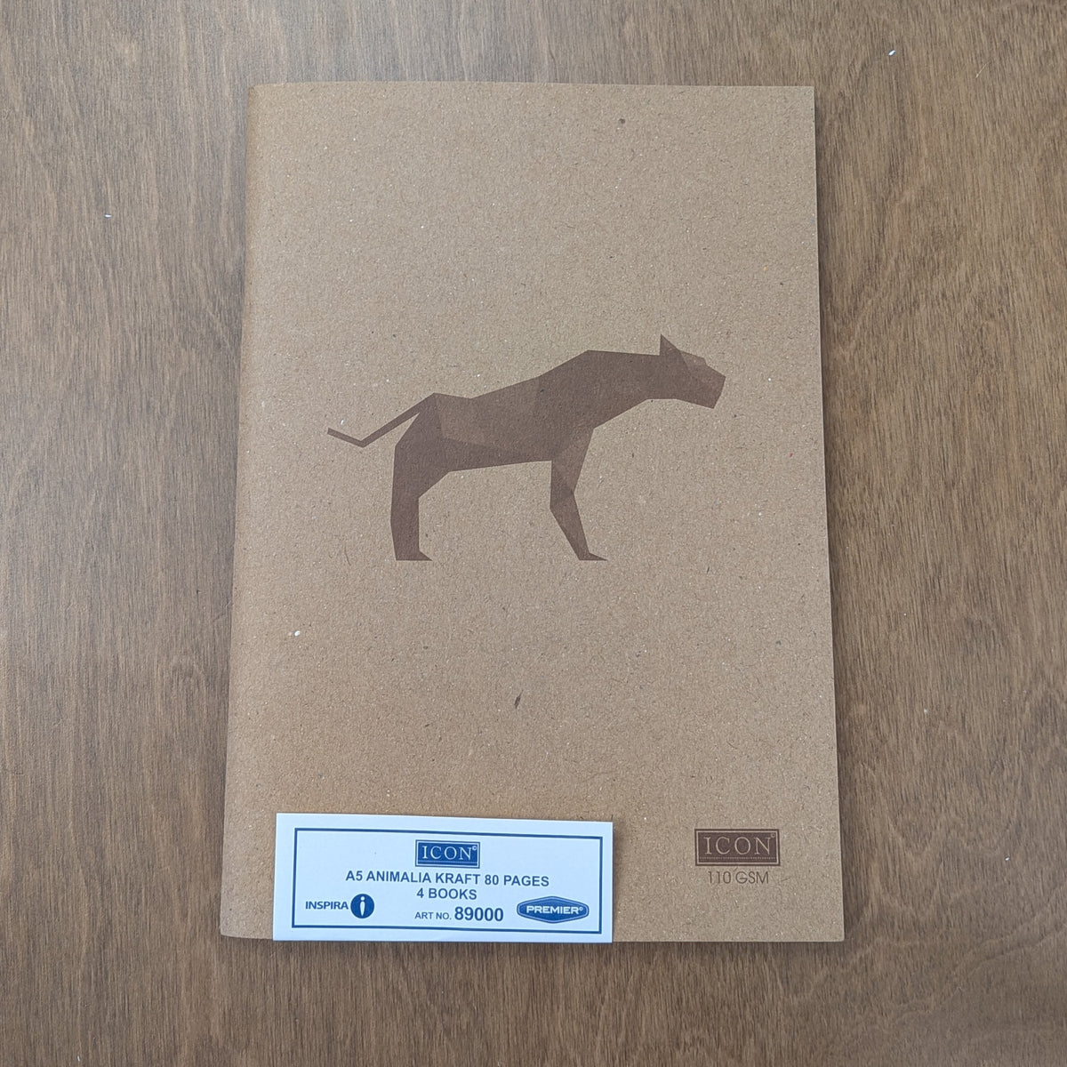 A brown kraft paper notebook cover with a geometric dog illustration, placed on a wooden surface.