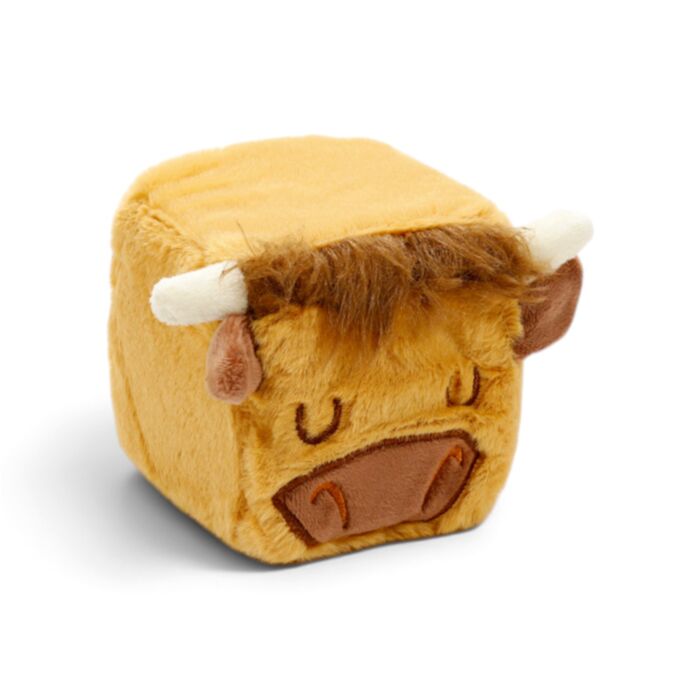 A plush cow cube-shaped squishy toy in yellow and brown with white horns, photographed on a clean white background.