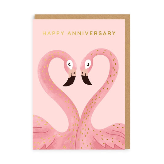 Greeting card with an illustration of two pink flamingos using their necks to form a love heart on a light pink background. The words "Happy Anniversary" are written in gold above them.