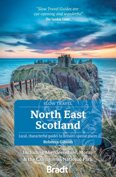 The cover of the book, showing a scenic castle on a small island surrounded by the ocean a sunset. A large blue box with "SLOW TRAVEL NORTH EAST SCOTLAND LOCAL, CHARACTERFUL GUIDES TO BRITAIN'S SPECIAL PLACES." written in it, along with the author's name.